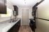 Modern kitchen with sleek granite countertops, stylish dark cabinets, and stainless steel appliances, offering ample workspace and a contemporary feel.