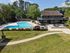 Luxurious apartment complex featuring a spacious pool area, tranquil green landscaping, and inviting outdoor seating perfect for relaxation.
