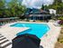 Inviting apartment complex swimming pool with sun loungers, surrounded by lush greenery and modern architecture.