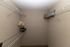 Spacious walk-in closet with wire shelving, featuring a decorative potted plant and neatly stored items.