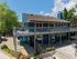 Charming two-story home with a spacious wrap-around balcony, modern exterior design, and lush greenery in a serene setting.