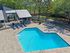 Inviting outdoor pool area with stylish lounge chairs and lush greenery, perfect for relaxation and leisure.