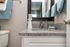 Elegant bathroom with granite countertop, stylish fixtures, and neatly arranged teal towels, exuding modern luxury.