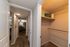 Inviting apartment hallway leading to a cozy bedroom, featuring a spacious walk-in closet with ample shelving.