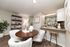 Inviting dining area with elegant round wooden table, plush white chairs, and a modern kitchen countertop with stylish bar stools, perfect for social gatherings.