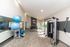 Bright and modern fitness room featuring exercise equipment, yoga mats, and large windows overlooking a lush landscape.