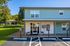 Charming apartment exterior with modern facade, accessible parking, and scenic green surroundings featuring a cozy gazebo.
