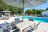 Luxurious outdoor pool area with elegant patio furniture and vibrant greenery, perfect for relaxation and entertaining.