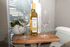Elegant dining setup featuring a bottle of Chardonnay with two wine glasses on a wooden tray, enhancing the cozy ambiance of the stylish apartment.