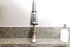 Modern kitchen faucet with sleek stainless steel design against elegant granite countertop.