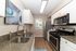 Modern kitchen design with sleek granite countertops, stainless steel appliances, and contemporary art, offering a bright and stylish cooking space.
