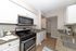 Bright and modern kitchen with sleek granite countertops, stainless steel appliances, and elegant white cabinetry.