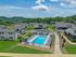 Charming residential community with a sparkling outdoor pool, surrounded by lush greenery and inviting walkways.