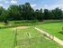 Welcoming green space with fenced dog park and lush trees, offering tranquility and outdoor enjoyment.