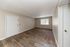 Inviting apartment interior showcasing a spacious living area with large window, neutral tones, and elegant wood vinyl flooring.