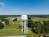 Scenic aerial view of Portland featuring a prominent water tower, lush greenery, and expansive residential areas under a clear blue sky.