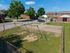 Charming community playground with swings and a basketball court set within a well-maintained residential area, offering a perfect outdoor space for families.