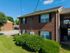 Inviting brick apartment complex with well-maintained landscaping, ample parking, and serene surroundings.