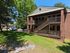 Charming two-story brick apartment with spacious balconies, nestled in a lush, green landscape and featuring convenient parking.