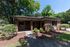 Charming brick building amidst lush greenery, offering a welcoming setting for laundry and office needs.
