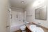 Bright and inviting bathroom boasting modern fixtures, a pristine bathtub, and elegant countertop space.