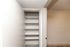 Spacious built-in shelving unit in a modern closet with clean white walls and ample storage space.