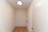 Cozy nook with fresh white walls and warm tiled flooring, perfect for storage or customization.