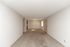 Spacious apartment interior with elegant beige carpet and fresh, white walls, illuminated by natural light from the window, offering an inviting and versatile living space.