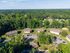 Scenic aerial view of charming apartment buildings surrounded by lush greenery and ample parking, showcasing a serene residential area.