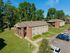Charming brick apartment building in a serene green neighborhood with ample parking and lush surroundings.