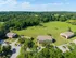 Spacious apartment complex surrounded by lush greenery, offering serene rural views and ample parking.