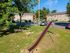 Inviting apartment complex exterior view with well-maintained playground featuring a slide and swings, surrounded by lush greenery and ample parking space.