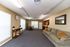 Bright open-concept living space featuring a cozy sofa, a dining area, and a functional kitchen with a large refrigerator.