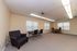 Spacious and versatile room with modern lighting, featuring comfortable seating and a cozy dining area.