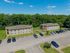 Charming apartment complex surrounded by lush greenery, featuring ample parking space and a serene atmosphere.