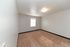 Bright and spacious bedroom with plush carpet and modern lighting, offering ample natural light through a large window.
