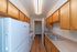 Cozy galley kitchen with modern fixtures, ample wooden cabinetry, and sleek countertops for an efficient cooking experience.