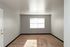 Bright, spacious room with plush carpet and large window, perfect for creating a cozy living area.