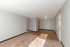 Bright and spacious living area with dual carpet and wooden flooring, featuring stylish neutral walls and ample natural light.