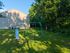 Charming playground with a swing set and slide, nestled amidst lush greenery, perfect for family fun in a serene setting.