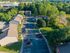 Elevated view of charming apartment complex nestled amidst lush greenery, featuring ample parking and serene surroundings.