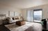 Bright and inviting living room with elegant decor, cozy couch, stylish lamps, and sliding glass doors opening to a scenic balcony view.