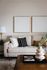 Elegant living room featuring a stylish beige sofa with modern cushions, minimalist wall art, and a chic coffee table centerpiece.