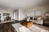 Modern living and dining area with warm tones, elegant decor, and cozy seating, featuring a stylish coffee table and artistic wall accents.