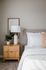 Chic bedroom corner with a modern white lamp, wooden nightstand, and plush bedding for a cozy retreat feel.