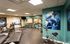 Modern fitness center with high-quality equipment, including treadmills, stationary bikes, and free weights. Spacious and well-lit with motivational decor.