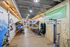 Vibrant retail space showcasing colorful kayaks and watersports equipment on modern wooden displays, illuminated by stylish overhead lighting.