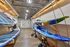 Modern storage area showcasing colorful kayaks and paddleboards on sleek wooden racks, with bright lighting and industrial ceiling design.