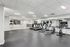 Modern fitness center equipped with treadmills, exercise bikes, and organized gym accessories in a bright, spacious setting.