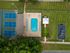 Aerial view showcasing luxurious amenities: pristine swimming pool, adjacent tennis courts, lush green landscaping, and a delightful playground.